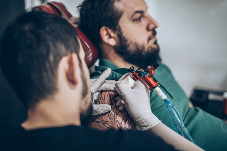 tatuażysta robiący tatuaż mężczyźnie